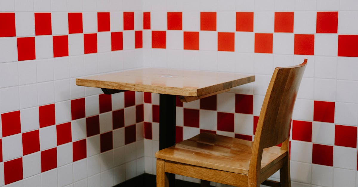 wooden chair and table in a minimalistic corner with red and white checkered tiles